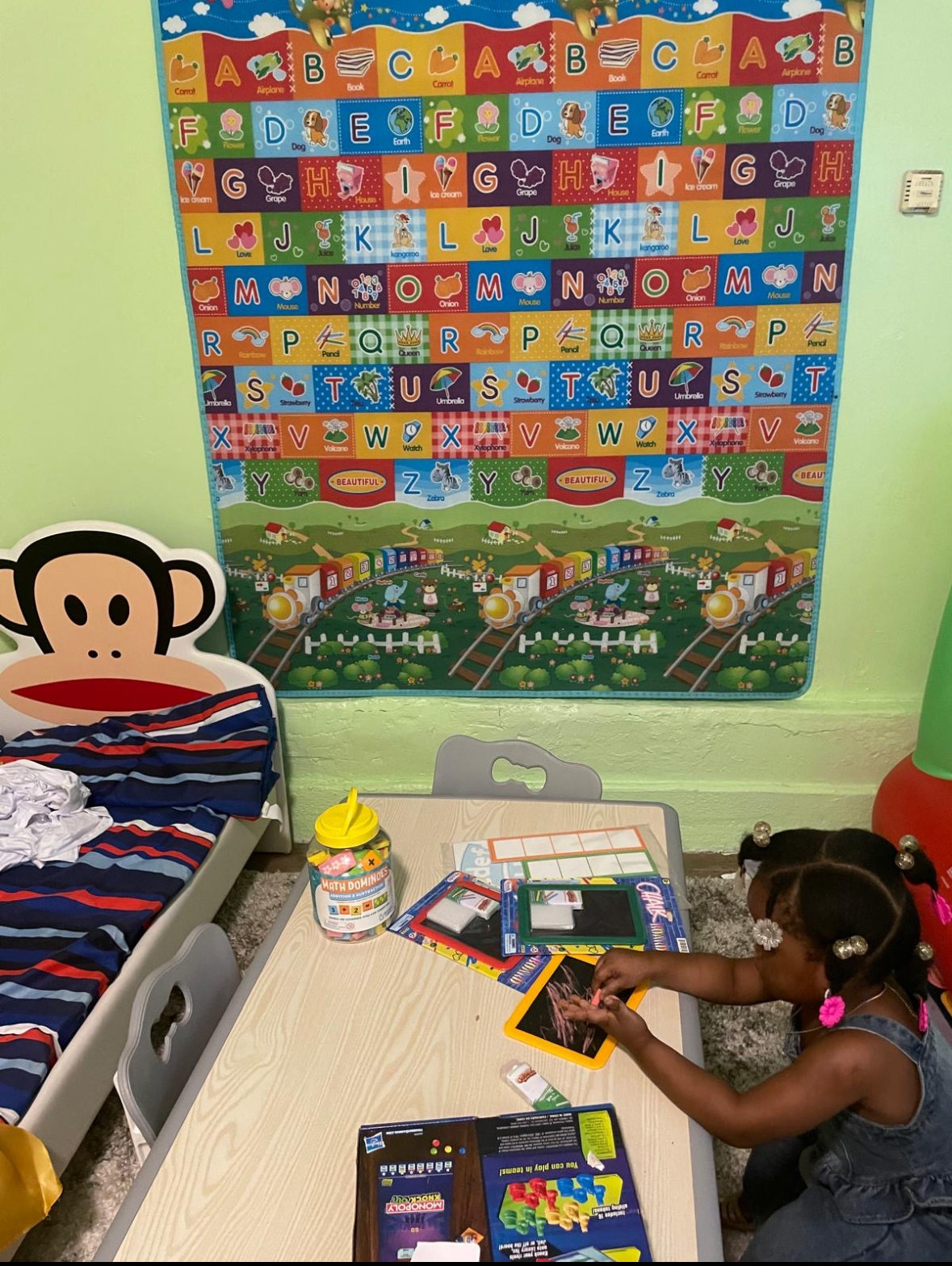 Bright learning area at Zion Family Home Day Care with alphabet poster and play space